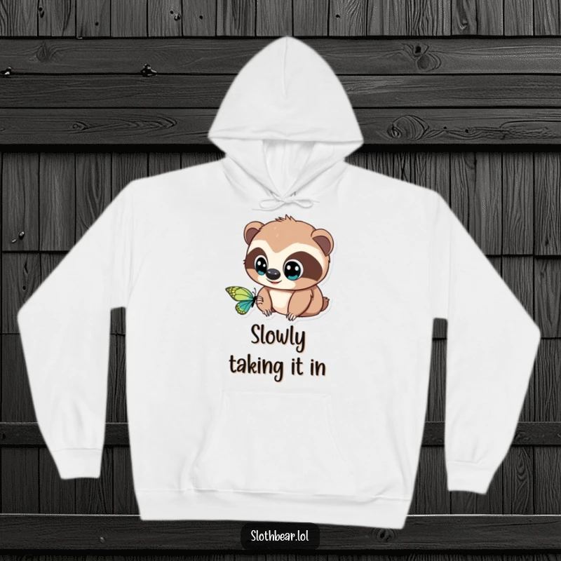 Funny Hoodie: A delightful sloth bear with large, curious eyes is captivated by a beautiful butterfly, offering warmth and humor.